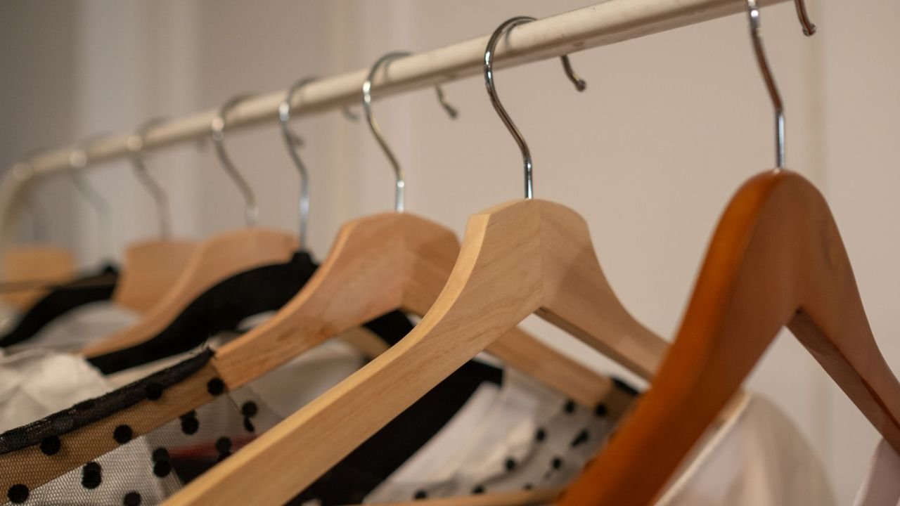 Wooden hangers with clothes on a rail