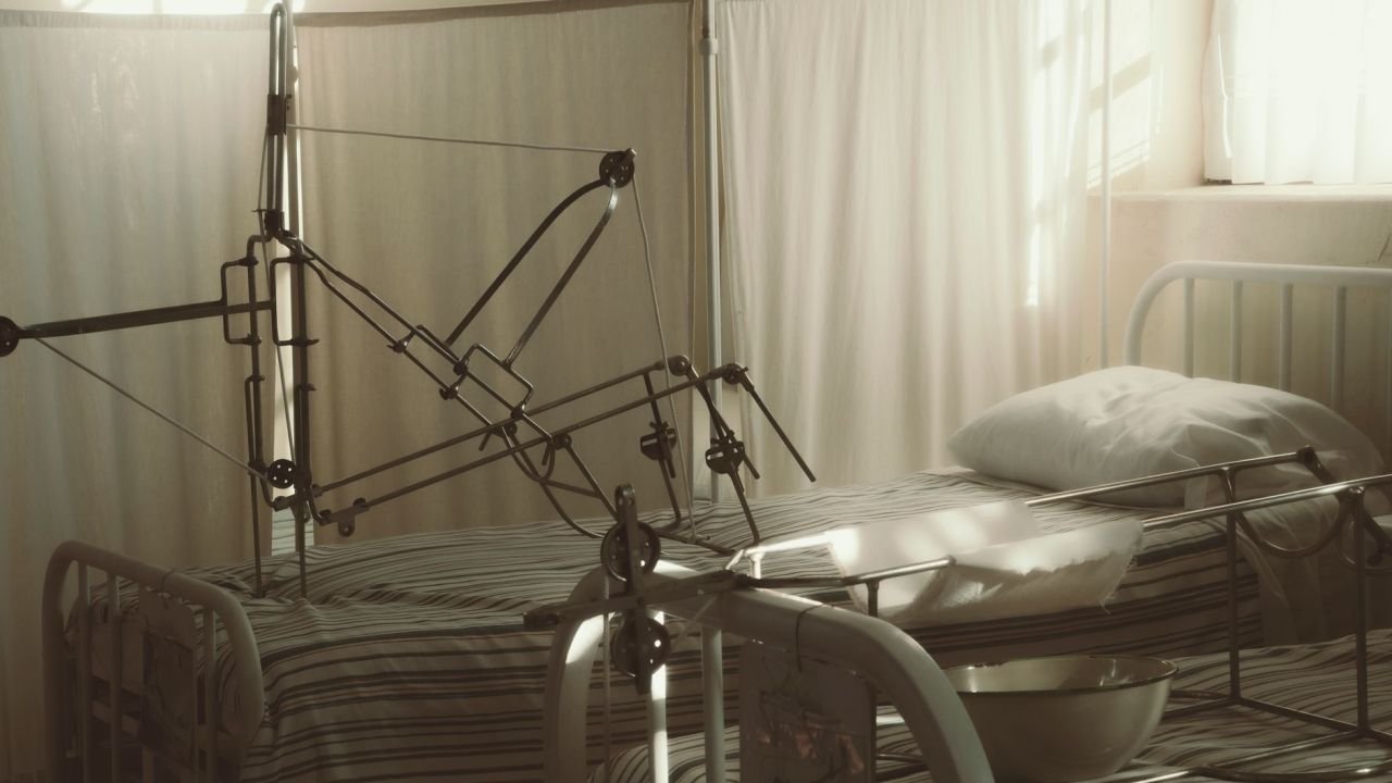 An empty hospital bed in a quiet, sunlit room