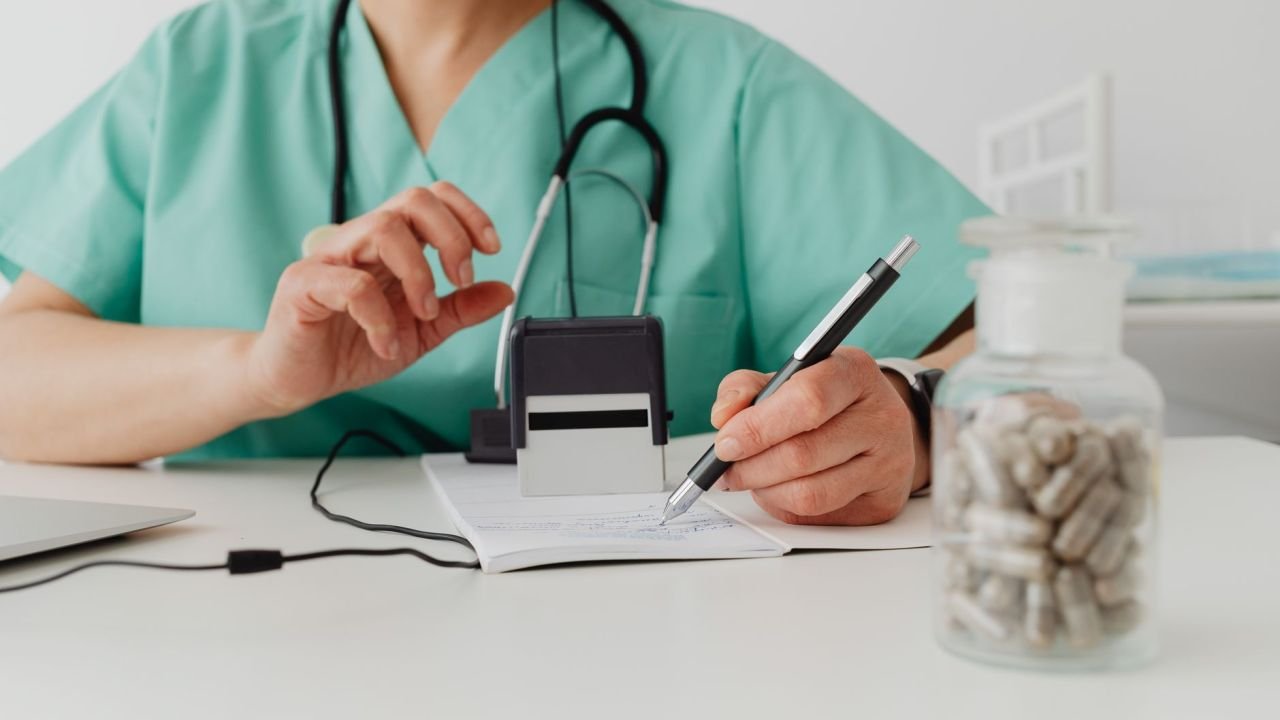 A clinician writing a prescription at a desk