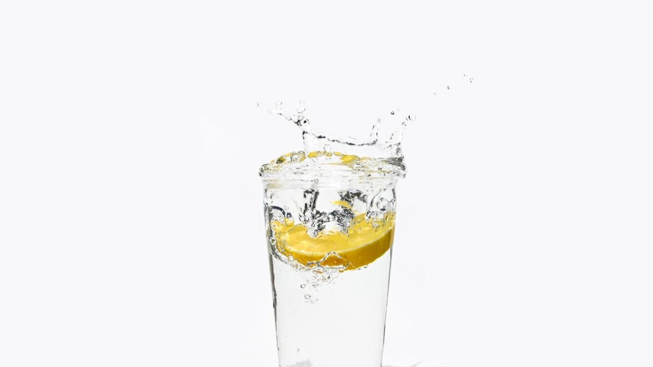 A slice of lemon splashing into a glass of water