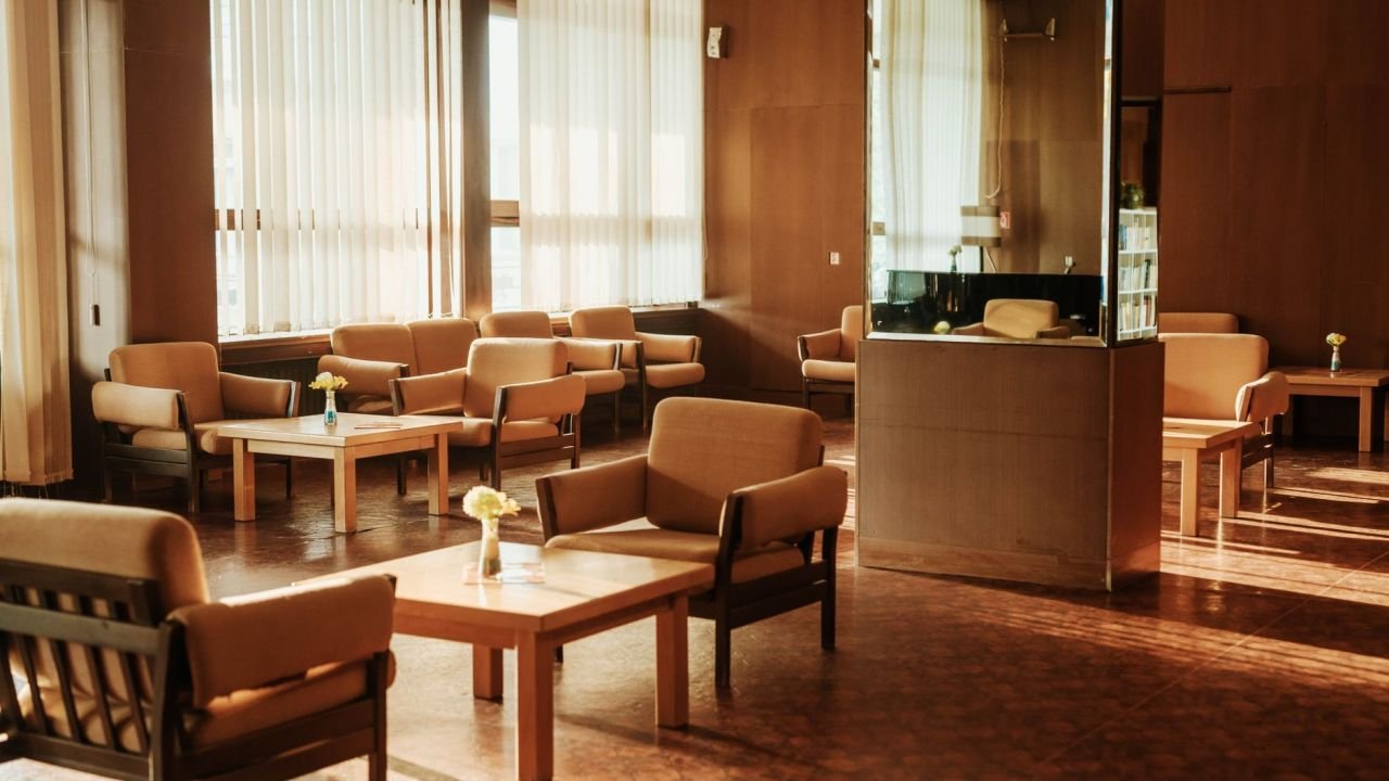 An empty waiting area with armchairs and warm sunlight